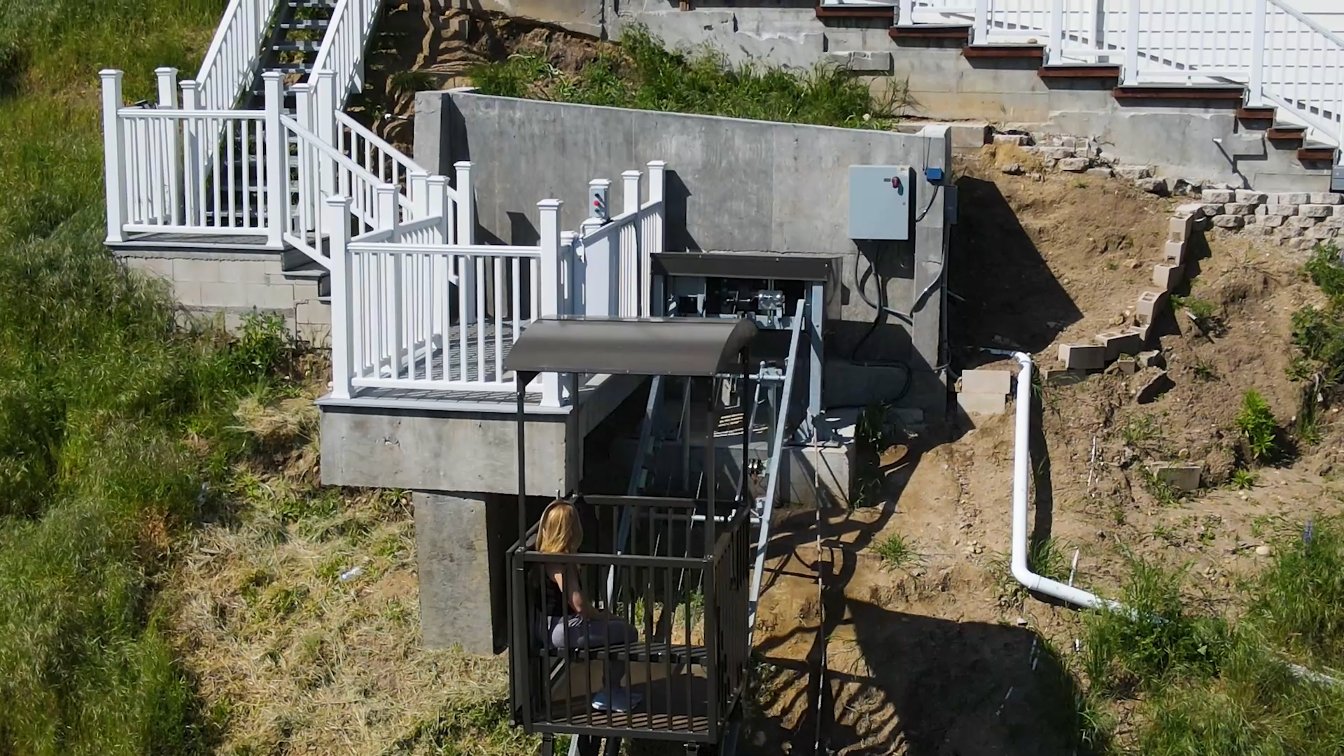 Aerial view of completed hillside lift system with white railings and concrete platform at 50 Saddlebow Bell Canyon