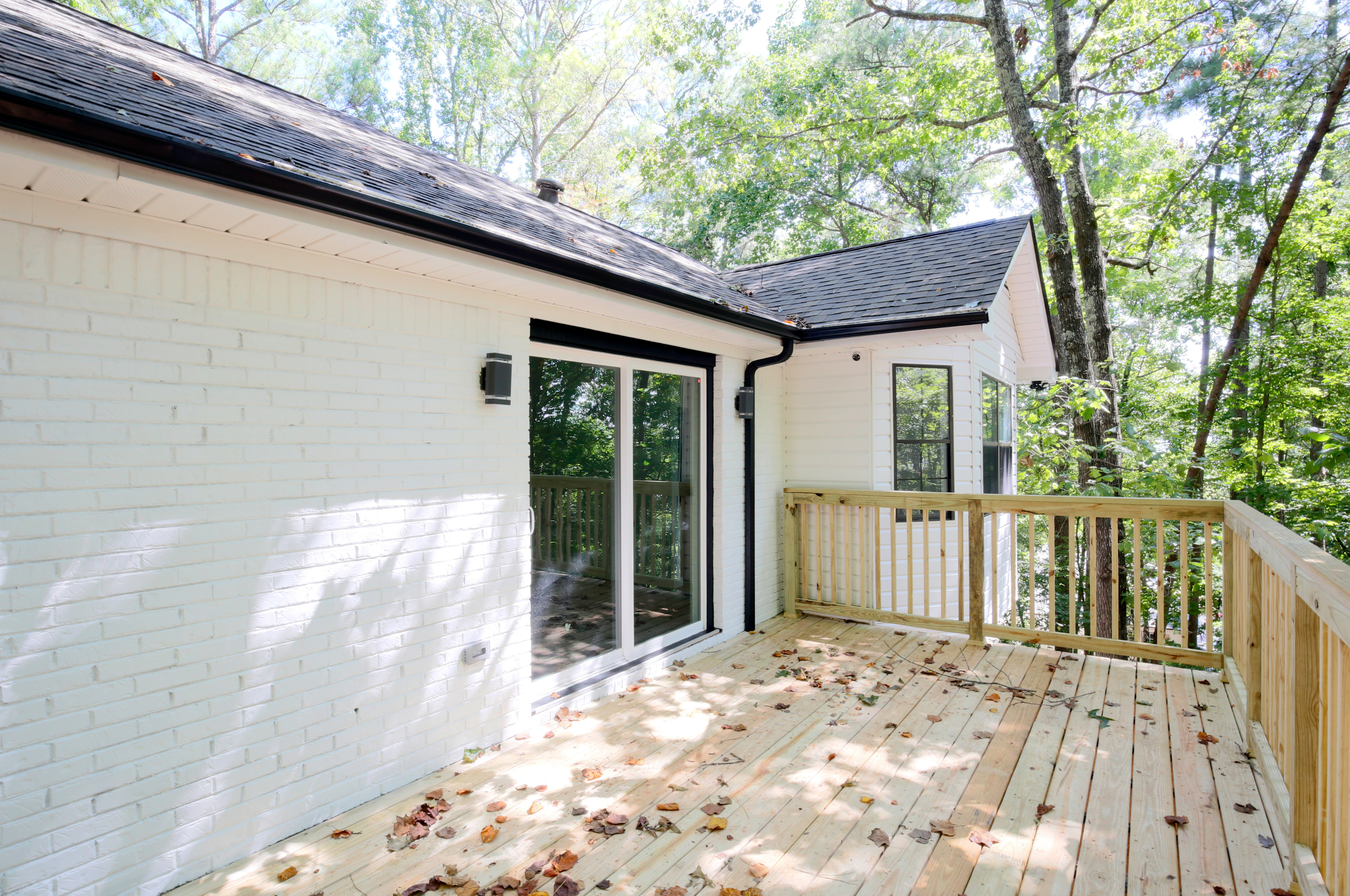 Newcomb Road exterior deck with wood railings and mature trees